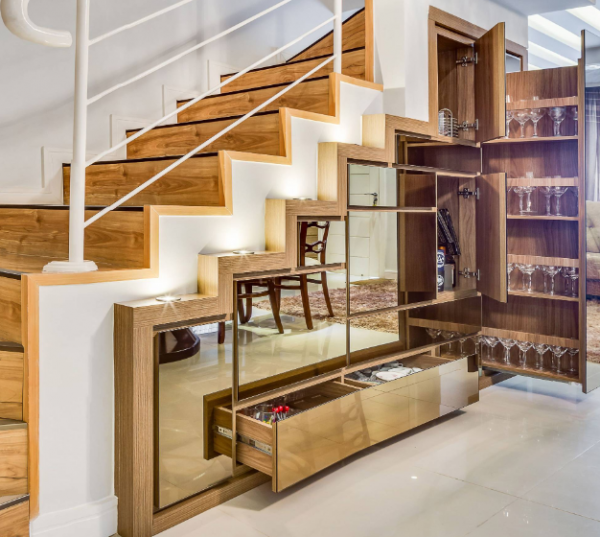 Lemari bawah tangga dengan kombinasi rak terbuka dan pintu kaca